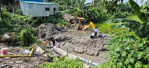 क्षतिग्रस्त पाइप की मरम्मत करते कर्मचारी