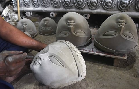 An artist carefully shapes Goddess Durga’s face with clay at a workshop in Kumartuli, Kolkata, ahead of Durga Puja.