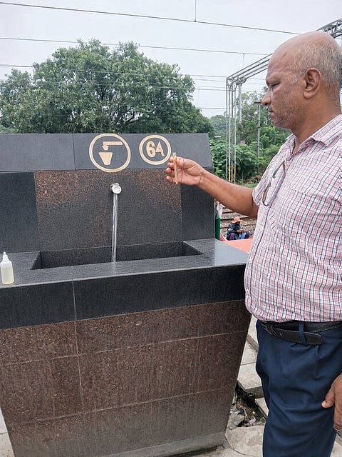 पानी के नल क जांच करते हुए अधिकारी