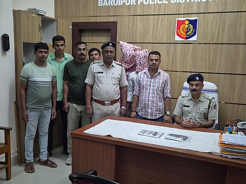 गिरफ्तार अभियुक्तों को पुलिस अधिकारी दिखाते हुई 