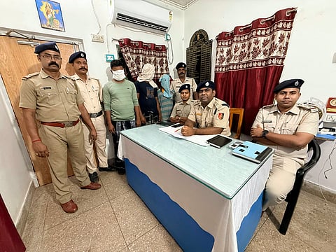 पुलिस अधिकारी गिरफ्तार अभियुक्तों को दिखाते हुए