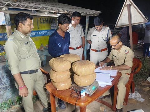 बरामद गांजा के साथ गिरफ्तार अभियुक्त से पूछताछ करती पुलिस