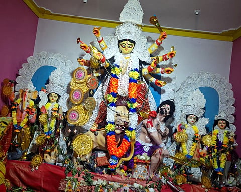 कन्या संतान की कामना से शुरू हुई पूजा 72 साल बाद भी कायम है परंपरा
—डोबराना के पात्रबाड़ी में आज भी पूर्वजों की रीति से होती है मां दुर्गा की आराधना
फोटो : पात्रबाड़ी की दुर्गापूजा
जामुड़िया : कन्या संतान की कामना से करीब 72 वर्ष पहले शुरू हुई दुर्गापूजा आज भी डोबराना गांव के पात्रबाड़ी में उसी आस्था और परंपरा के साथ जारी है। समय के साथ घर का स्वरूप बदला, कच्चे मकान की जगह पक्की छत बन गई, लेकिन पूजा की विधि और उससे जुड़ी पारिवारिक मान्यताओं में कोई बदलाव नहीं आया।
पात्र परिवार के सदस्यों के अनुसार, करीब 72 वर्ष पहले परिवार के पूर्वज स्वर्गीय वाराणसी पात्र ने इस दुर्गापूजा की शुरुआत की थी। उस समय परिवार में कोई कन्या संतान नहीं थी। कन्या संतान की कामना से उन्होंने अपने स्तर पर मां दुर्गा की आराधना शुरू की। परिवार का मानना है कि पूजा शुरू होने के बाद वंश में पहली कन्या संतान का जन्म हुआ। इसके बाद यह पूजा परिवार की आस्था और परंपरा का अभिन्न हिस्सा बन गई।
पूजा की शुरुआत के समय मंदिर टीन की छत वाले मिट्टी के घर में था। वर्तमान में वहां पक्की छत है, लेकिन पूजा की पुरानी रीति आज भी कायम है। पात्र परिवार की सदस्य पौलमी पात्र ने बताया कि उन्होंने अपने पूर्वजों से इस पूजा का इतिहास सुना है। पीढ़ी-दर-पीढ़ी यह परंपरा आगे बढ़ रही है।
परिवार के अनुसार, जीताष्टमी के अगले दिन मंदिर में घट स्थापित कर पान-सुपारी के माध्यम से मां दुर्गा को मायके आने का निमंत्रण दिया जाता है। महालया के बाद षष्ठी से नवमी तक परिवार के सदस्य सात्विक भोजन करते हैं। षष्ठी को विवाहित दंपती के माध्यम से मां का अधिवास कराया जाता है। मिट्टी के बर्तन में हविष्य भोजन तैयार कर ग्रहण करने की भी परंपरा है। सप्तमी से मुख्य पूजा शुरू होती है।
अष्टमी को दूध और गुड़ से तैयार विशेष मिठाई की प्रतीकात्मक बलि दी जाती है। दशमी को मां को ‘मछली की यात्रा’ कराकर विदाई दी जाती है।
गोपीनाथ पात्र, अर्क पात्र और माधव पात्र ने बताया कि पूजा पारिवारिक होने के बावजूद ग्रामीण भी इसमें उत्साह से शामिल होते हैं। आने वाली पीढ़ियों तक इस परंपरा को कायम रखने का प्रयास जारी रहेगा।