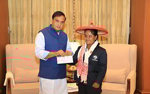 Image of Assam Chief Minister Himanta Biswa Sarma while handing over a cheque to the World Cup-winning blind cricketer Simu Das
