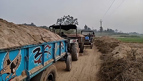 Image of unregistered tractors carrying sand during the mining activities that take place along the Kapili River in Lanka