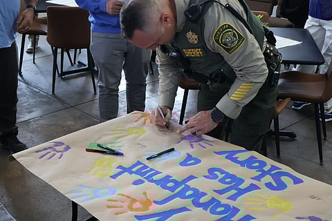 Sheriff Grant Nicely signing the banner from a Johnson County Child Abuse Prevention Event