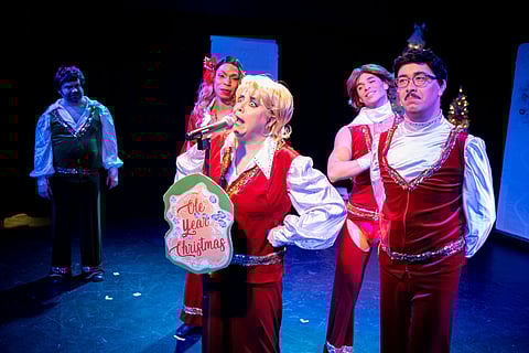 "War on Christmas" cast members, from left to right: Scott Shoemaker, Adé, Mandy Price, Glory Joel, and Major Scales, all of them performing in "War on Christmas," making various smiling facial expressions in response to something Mandy Price is singing into the mic.