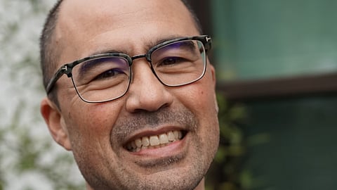 Close-up of a middle-aged Asian American man wearing glasses.