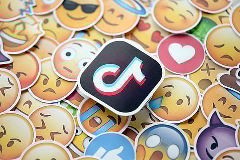 TikTok logo sticker surrounded by assorted emoji stickers showing different emotions.