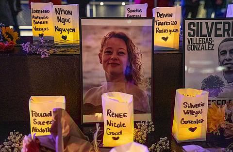 An altar honors Renee Nicole Good. A photo of her smiling is surrounded by candles.