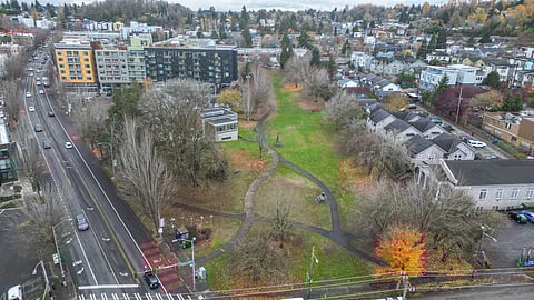 Aerial view of Columbia Park in Seattle’s Columbia City neighborhood, showing winding paths, grassy areas, autumn trees, and surrounding residential buildings.
