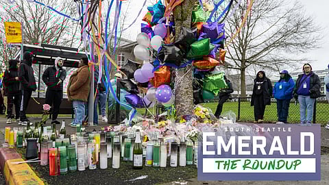 A memorial for two teenagers killed in a shooting at a Rainier Beach bus stop. People stand around the memorial of candles, balloons, and ribbons, and a sign near the bus stop reads "Bus Stop Closed."