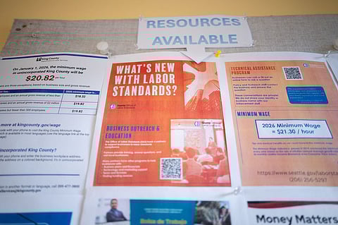 Flyers about Seattle labor standards and minimum wage posted on a bulletin board at Villa Comunitaria.