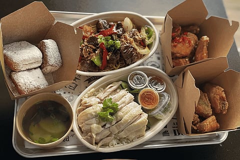 A tray of Mangosteen's dishes, including Hainanese chicken, garlic noodles, wings and beignets.