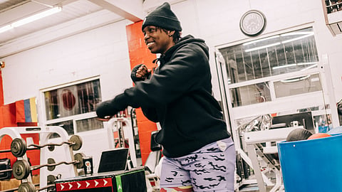 Kayla Floyd smiles while training in a boxing stance inside a gym.