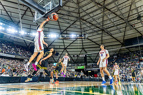 A basketball player dunks a ball.