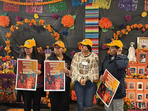Community members gathered holding signs about immigrant rights.
