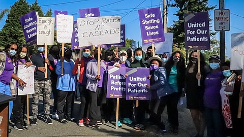 Health care workers holding purple and white protest signs that say things like "United For Our Patients" (Image: SEIU 1099NW)