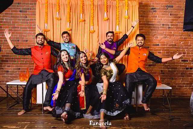 A group of dancers doing various poses and smiling at the camera