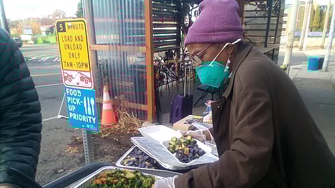 Yvette Dinish (pictured) purchased her storefront close to Rainier Beach's worker-owned restaurant Jude's before the pandemic. Since the pandemic, it has naturally evolved into a free food pantry supplied with extra food from community partners. It is open to the public every Thursday and Friday. (Photo courtesy of Yvette Dinish.)