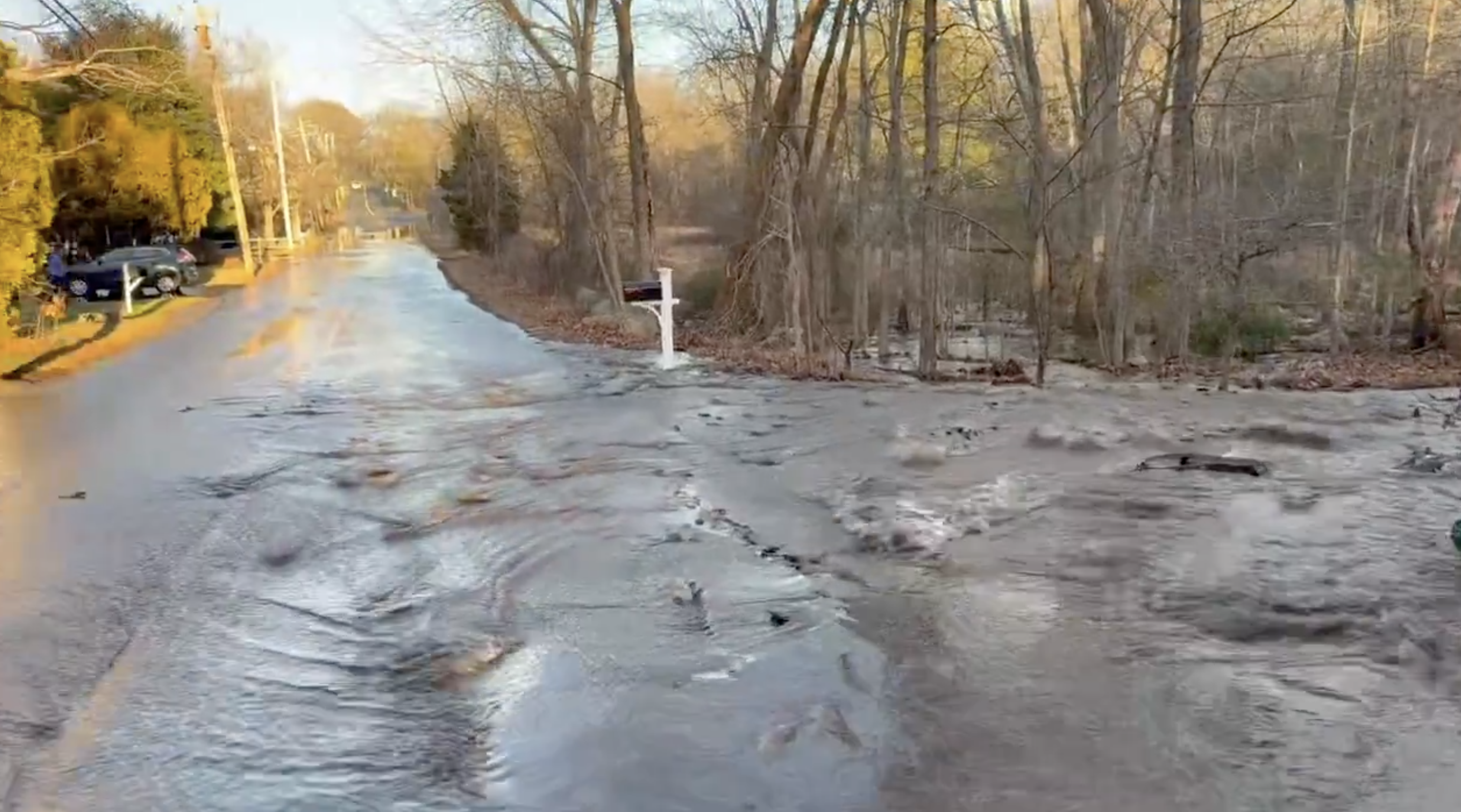 Water flows down the street from a water main break on Cohasset