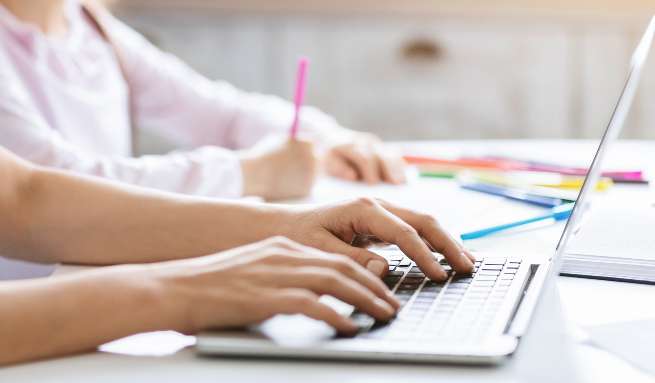 Student typing on laptop.