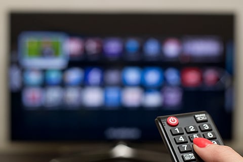 a woman uses a cable tv remote