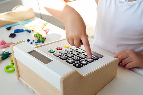 A kid with a toy cash register