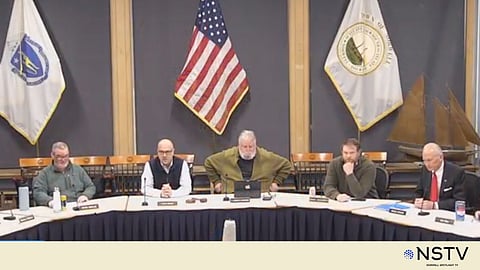 Norwell Select Board members seated at a long table in a town hall meeting room, discussing economic growth strategies.