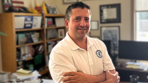 A man standing in his town hall office. 