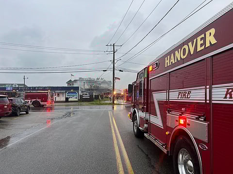 a red fire truck from Hanover parks outside of a burning restaurant with smoke billowing around- Firefighters from multiple South Shore towns battle a blaze at 291 Ocean Street in Marshfield, early morning of August 1, 2025.