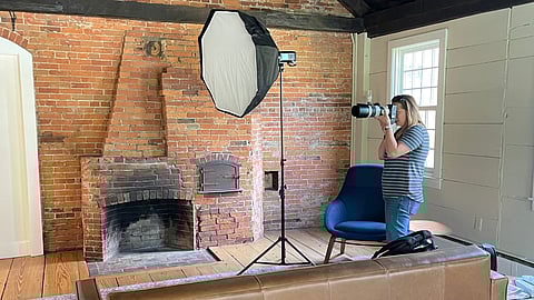 A photographer confidently poses her subject in their workspace during a brand photoshoot, showing authenticity and professionalism.