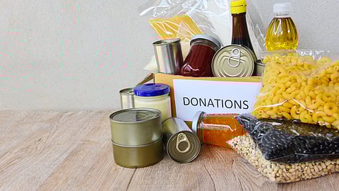 A picture of donations for a food pantry- Scituate Food Pantry sign highlighting new evening hours for local families.