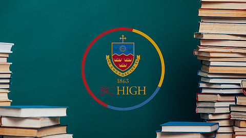 stack of books against a chalkboard with bc high logo on it