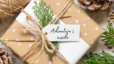 Picture of a gift wrapped in brown paper with a tag that says "adventure's inside"