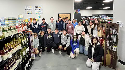 students from a youth substance prevention group pose in a liquor store