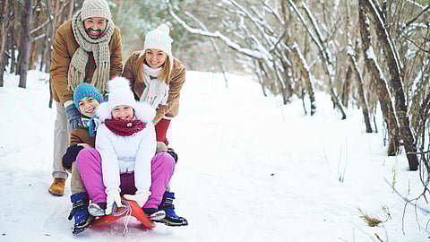 Families walking on a wooded trail covered in winter snow on the South Shore.