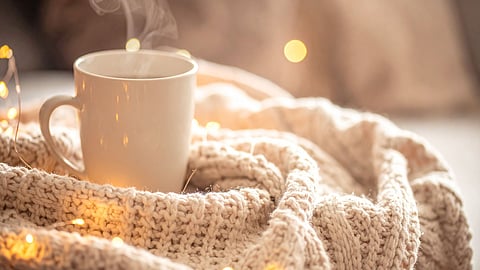 A warm mug of bone broth on a winter morning, symbolizing calm routines and staying grounded during the busy December season.