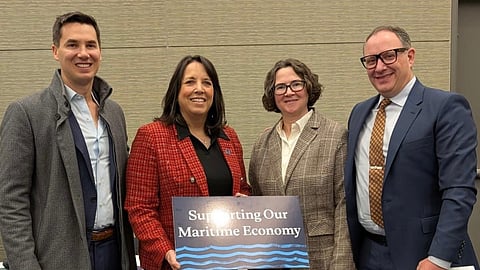 A group of white people stand holding a sign that says Supporting our Maritime economy