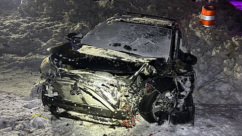 A damaged black car in the snow at night. The car was allegedly stolen and crashed by a 16-year-old Scituate resident