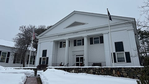 The outside of Duxbury Town Offices, a white paneled building, in the snow.