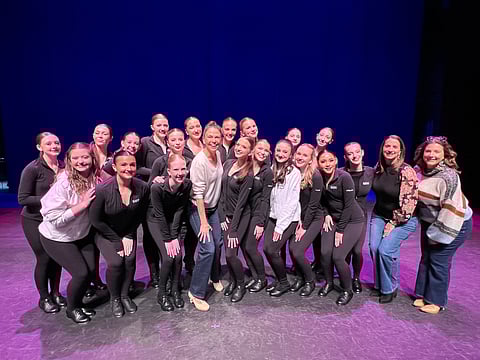 a group of tap dancers pose on a stage