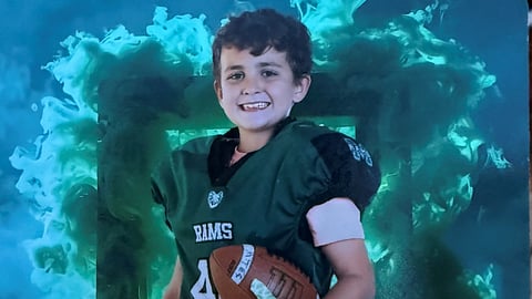 A young boy in a football uniform