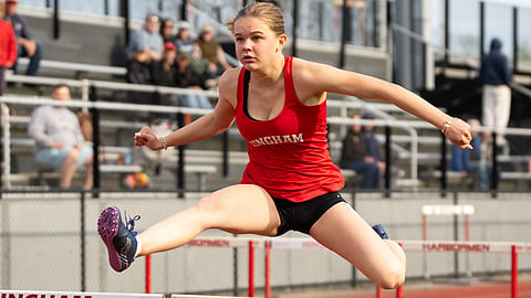 A Hingham High School student jumps hurdles in a previous meet. Meghan Koenen earned 3rd place in the 400 hurdles in the championship meet.