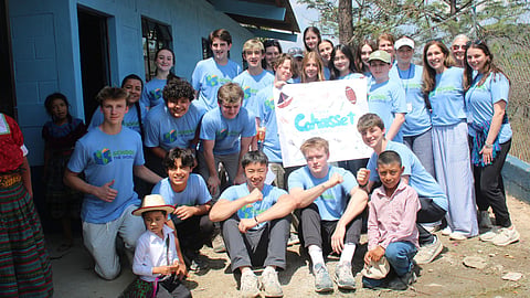 high school students wearing blue shirts pose during a mission trip 