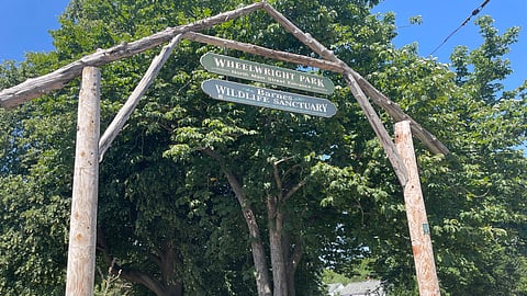 an image of a sign that says wheelwright park held up by a wooden frame