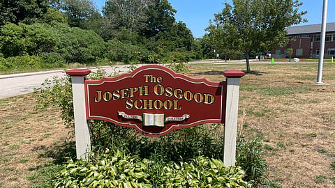 image of the osgood school sign in cohasset- sign is red with gold lettering