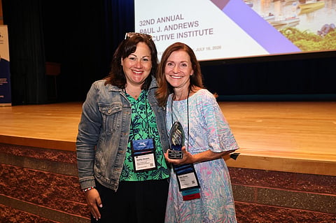 Two women with an award. 