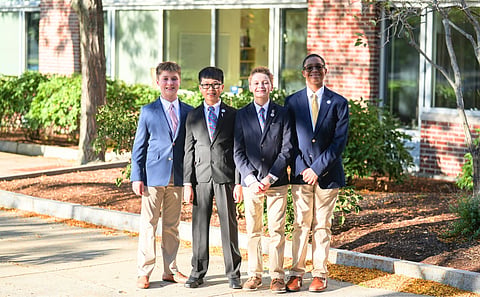 Photo of 4 middle school aged boys wearing sport coats and ties, smiling at the camera