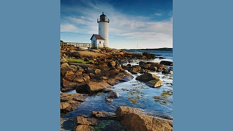 Photo of a lighthouse off the rocky shore of Massachusetts